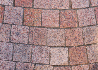 Curved granite paving stones in warm colors

