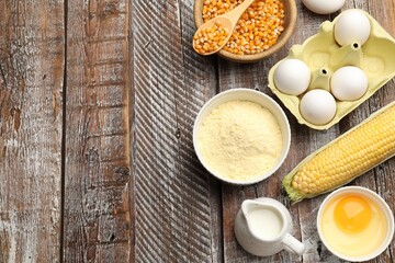 Cornbread preparation. Different ingredients on wooden table, flat lay. Space for text