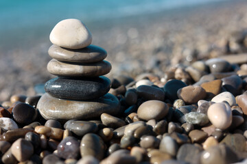 Stack of wet stones near sea on beach, closeup. Space for text