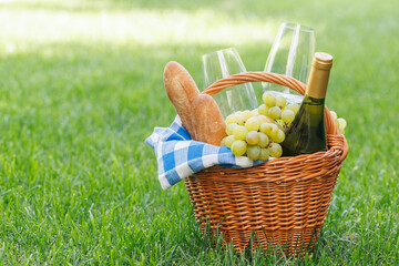 Picnic basket with wine, grapes, and baguette