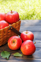 Basket of ripe red apples on a wooden table