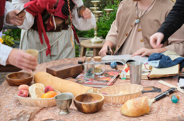 Medieval-themed tabletop roleplay scene with bread, fruit, wooden bowls, dice, books, and cards....