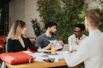 Fototapeta premium A group of four people having a professional meeting in an outdoor setting involving documents and conversation, exemplifying a collaborative business environment and teamwork.