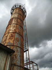 Old rusty factory pipe stretches skyward