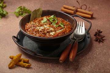 Dal makhani with cream and coriander leaves served in rustic bowl, accompanied by spices such as turmeric, cinnamon, and star anise, authentic Indian dish
