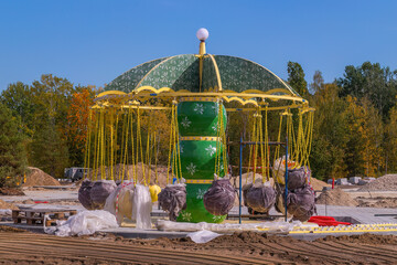 Colorful carousel under construction in serene outdoor setting