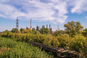 Abandoned industrial complex surrounded by lush greenery