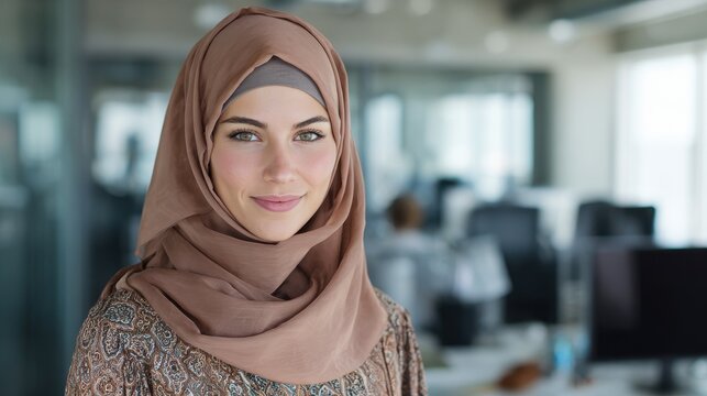 portrait of young muslim woman wearing hijab in office while looking at camera close up face of arabic business woman covered with headscarf smiling successful arab businesswoman in modern office no  - Powered by Adobe