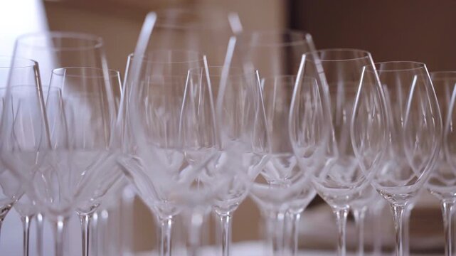 Close-up shot of clean transparent empty glasses on table in luxury restaurant, goblets prepared for guests aperitif, serving formal parties or ceremonies on high level