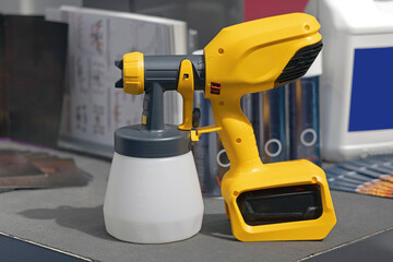 Fototapeta premium New Electric Paint Sprayer Air Gun at Desk in Workshop