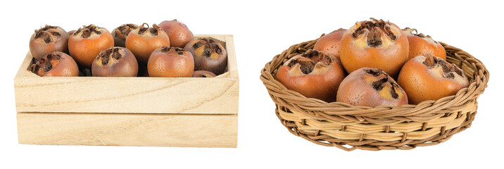 Brown fresh medlars in wooden box and a wicker basket isolated on white background. Mespilus germanica close-up
