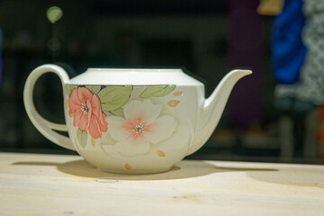 White glass teapot with pink and white floral motif