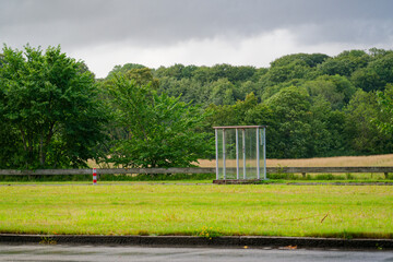 Transparent roadside shelter for rain on a grassy median