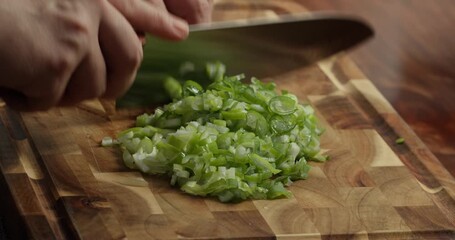 Of fresh herbs being chopped on a wooden cutting board over a wooden table. Close-up 4K shot of a chef chopping fresh spring onions, parsley, and dill on a wooden cutting board placed on a rustic - Powered by Adobe
