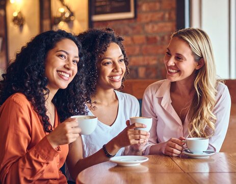 Generated image of three diverse women in a coffee shop, chatting and smiling while drinking coffee
