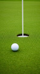 Golf ball on green grass with a hole and flag in the background. Golf course concept for sports game and competition.