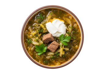 A high-angle, close-up view of a bowl of vibrant green soup, garnished with fresh herbs and chunks of meat.