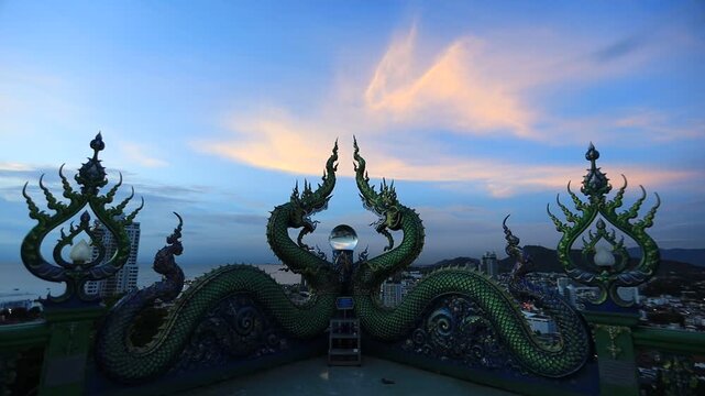 Video background of Chonburi city viewpoint. At the Samnaksong Khao Phra Khru viewpoint in the Sri Racha Thailand,a beautiful Naga statue and a white Buddha statue stand tall among the mountains.