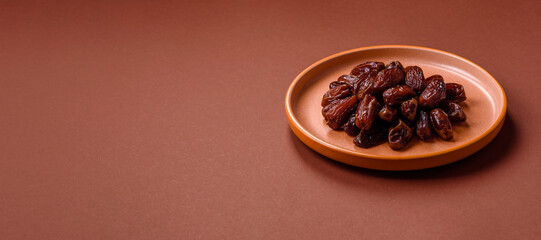 Dried dates in a ceramic plate, arabic food for the ramadan table. Dried dates as a food backgrounds