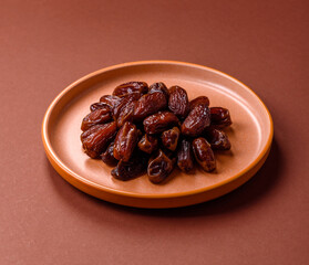 Dried dates in a ceramic plate, arabic food for the ramadan table. Dried dates as a food backgrounds