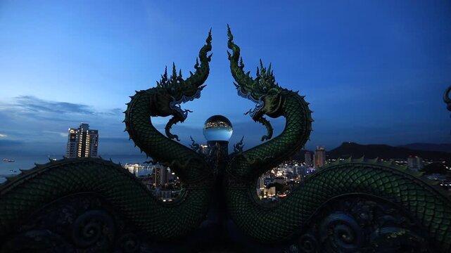 Video background of Chonburi city viewpoint. At the Samnaksong Khao Phra Khru viewpoint in the Sri Racha Thailand,a beautiful Naga statue and a white Buddha statue stand tall among the mountains.