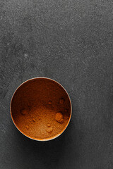 Healthy turmeric powder, in a steel container, on a slate