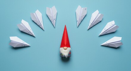 A small gnome figurine with a red hat surrounded by white paper airplanes on a blue background