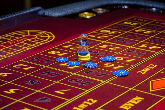 Roulette table in casino. Casino American Roulette gambling table with a wheel and playing chips on the layout.