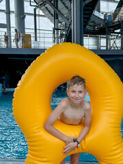 Teen boy with giant inflatable float in indoor water park