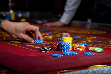 Man playing at the roulette table. A close-up vibrant image of multicolored casino table with...