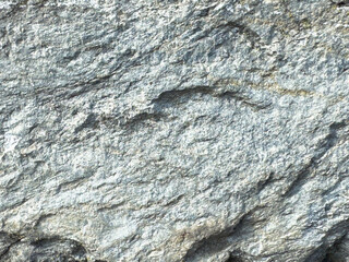 Close-up of rough gray rock texture with natural patterns