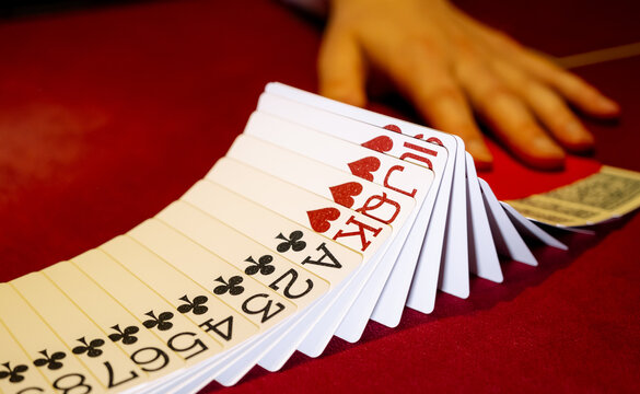 Croupier hands dealing cards on t blackjack poker table, gambling table with cards and chips. The croupier in the casino does a shuffle of cards. Person playing poker.