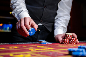 A man places a bet with chips in a casino. A player takes a lot of chips in a casino .Poker game in a casino in Las Vegas. Casino Black Jack table with poker cards