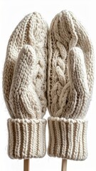 Pair of Knitted Cream Colored Mittens on Sticks Against White Backdrop