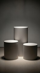 Three light gray cylindrical podiums, positioned in a minimalist,  setting, create a sophisticated display for showcasing various products.