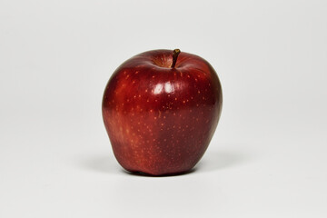 Red apple isolated on a table in close-up with copy space under a white background
