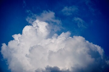 Towering cumulus cloud against deep blue sky