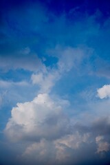 Brilliant white clouds rising beneath clear blue sky