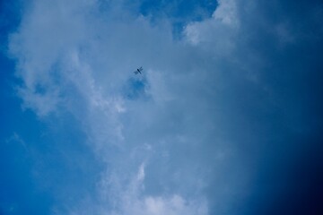 A Lone Dragonfly in vast blue sky with clouds