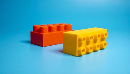 Fototapeta premium Two colorful plastic building blocks on a blue background