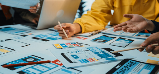 A vibrant workspace filled with team members collaborating on user interface design for mobile applications, showcasing colorful mockups, devices, and creative brainstorming. SACTR
