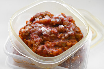 Frozen food in a plastic box container. Bolognese sauce leftover. Photo can be used for the concept of is frozen food healthy to eat or how do you keep frozen food fresh.
