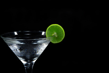 Ice water with lemon closeup shot on black background 