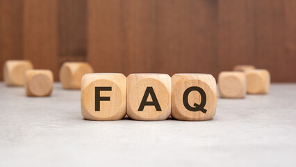 wooden cubes with the word FAQ on a table