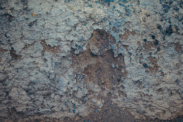 Close up view of a weathered wall with a rough, textured surface. The colors are predominantly blue and gray, with variations in shade and tone. The texture shows significant wear and deterioration