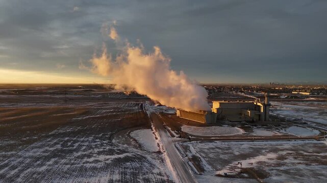 Power station sunrise arial cinematic shot with vapours rising under morning sky.
