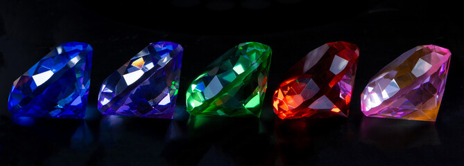 Colored polished gemstones on black background