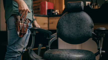 Male barber preparing tools in modern men's barbershop setting, retro tinting