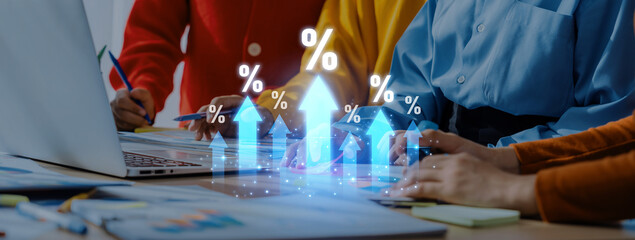 Team members collaborate on a financial growth strategy, using technology to analyze percentage metrics and display upward trends in a modern workspace. Trope