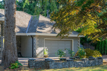 Garage door in luxury house with trees and nice landscape in Summer in Vancouver, Canada, North America. Day time on August 2025.